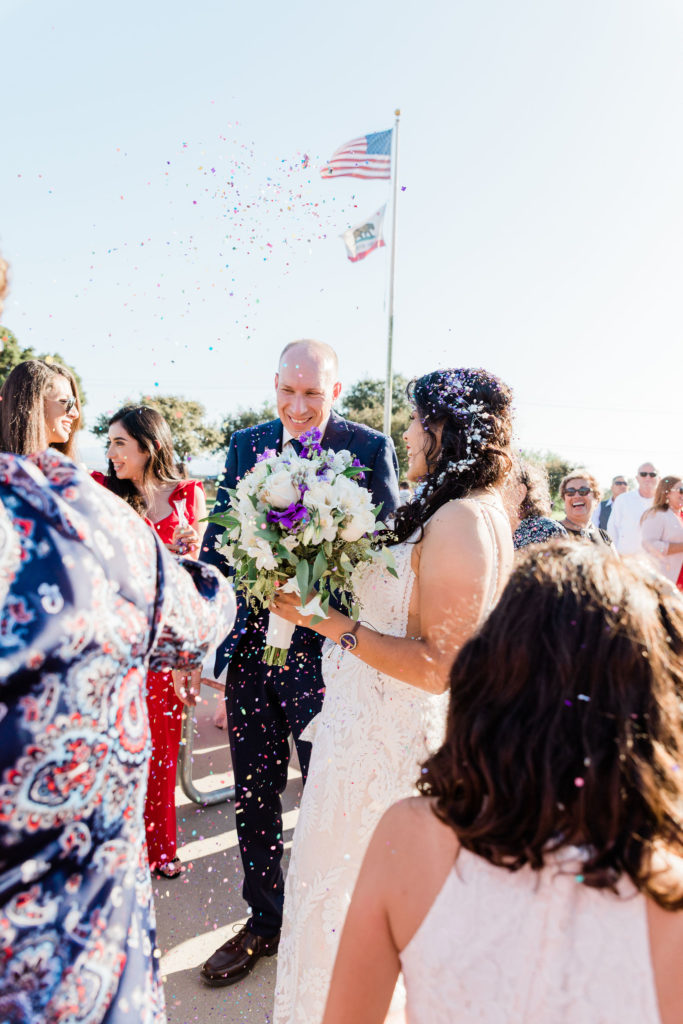 Wedding couple celebrating with confetti