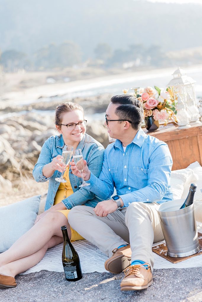 Engaged couple raise a glass on Carmel Beach
