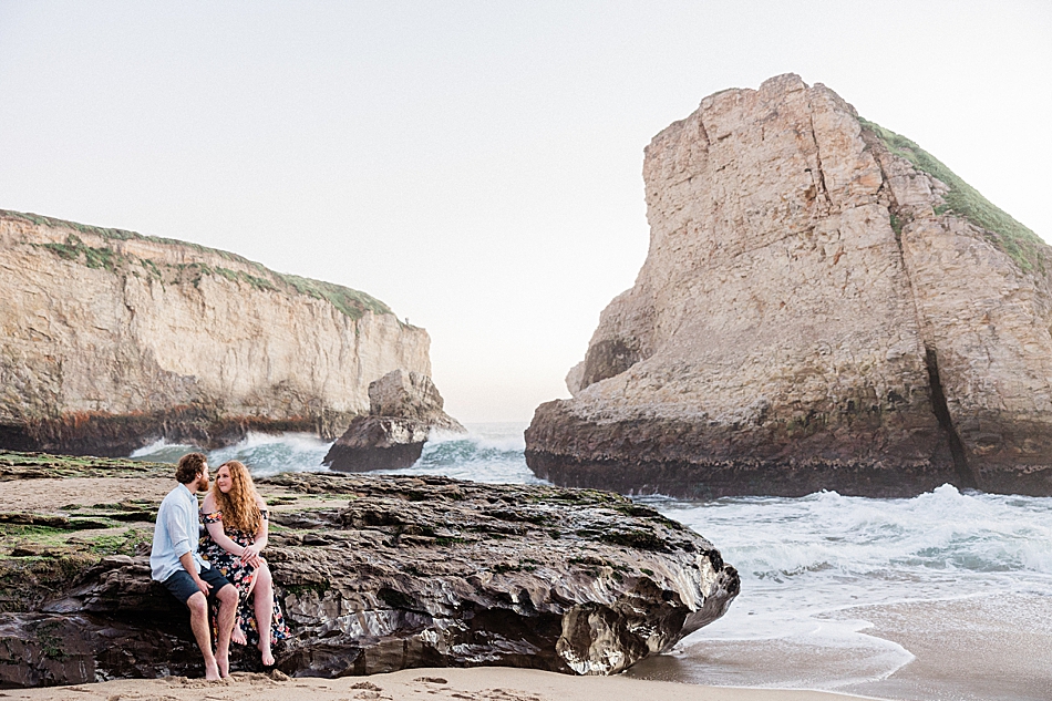 Couple talking in rock for beach engagement photos in Santa Cruz, California
