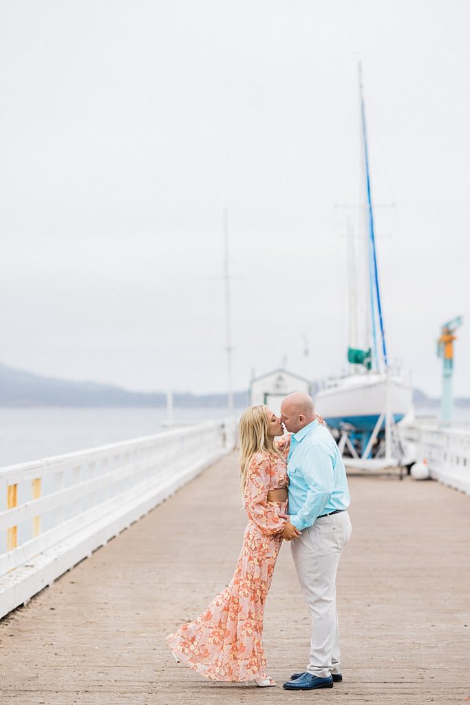 engagement photo couple kissing on a pier